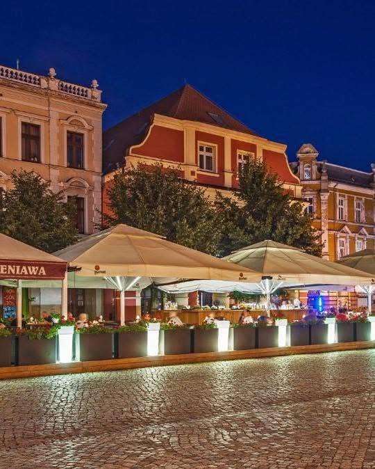 Kamienica Wieniawa i ogródek Belli przy Rynku w Lesznie wieczorem